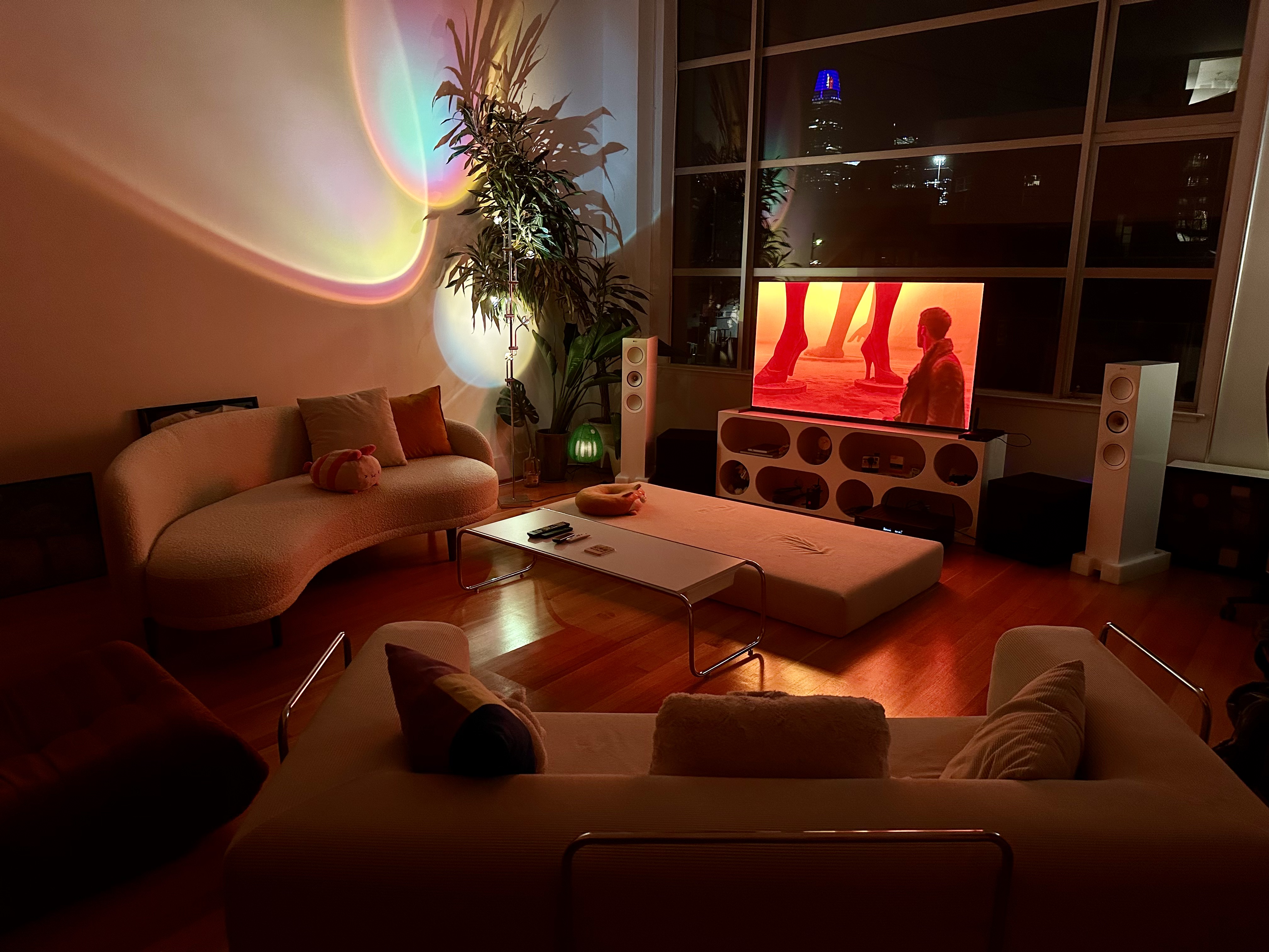 SF reference room: Sony Bravia 8 II flanked by KEF speakers, Blade Runner 2049 on screen, Salesforce Tower visible through industrial windows.